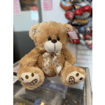 Plush teddy bear with a paw-print ribbon