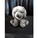 Gray plush dog toy sitting on a black surface