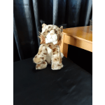 Plush spotted cat toy sitting on a black surface