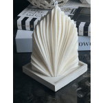 White shell-shaped decorative object on a square base