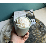 White flower candle in a pale green ceramic cup