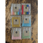 Six packs of colorful party candles arranged on a wooden surface.