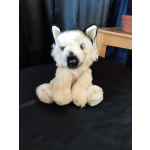 Plush white wolf stuffed animal sitting on a black surface