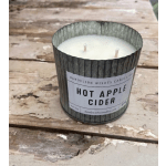 Hot apple cider candle in a metal tin on a rustic wooden surface