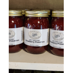 Jars of strawberry preserves with gold lids on a shelf