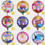 Nine colorful birthday foil balloons in a grid, including one Thomas & Friends balloon
