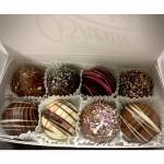 Box of assorted chocolate truffles with decorative drizzles and sprinkles