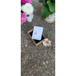 Floral necklace in a small gift box beside loose flowers