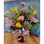 Mixed bouquet with yellow roses, pink lilies, and a plaid ribbon in a vase