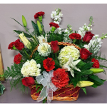 Basket arrangement of red roses, carnations, lilies, and white blooms with a ribbon bow