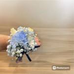 Small hand-tied bouquet of blue and white flowers with ribbon