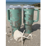 Two mint green Stanley tumblers on a beach with shells and starfish
