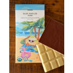 Chocolate bar packaging with two chocolate squares on a wooden surface