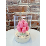 Pink flower-shaped candle in a clear glass container