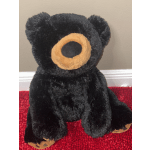 Black teddy bear plush with tan muzzle and paw pads