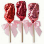 Three foil-wrapped rose-shaped lollipops on sticks with pink ribbon bows.