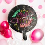 Black birthday balloon with neon cake graphic and pink balloons in the background