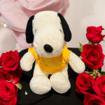 Plush Snoopy toy surrounded by red roses
