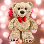 Plush teddy bear with a red bow tie and red roses behind it