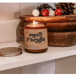 Lit candle in an amber glass jar with a holiday label