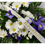 White daisies and purple irises with a memorial ribbon