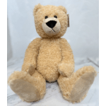 Plush teddy bear sitting upright on a light background