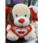 Plush dog holding a red heart pillow