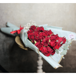 Bouquet of red roses wrapped in pale blue paper