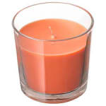 Orange candle in a clear glass tumbler
