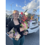 Woman holding a tropical flower arrangement and a wrapped gift