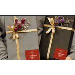Two wrapped gift boxes with small dried flower accents and gold ribbon