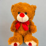 Brown teddy bear with a red bow on a plain background