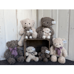 Five plush teddy bears arranged around a wooden crate