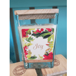 Glass candle jar with a cork lid and a floral label reading Joy