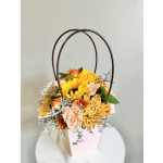 Basket arrangement of yellow and peach flowers with arched handles