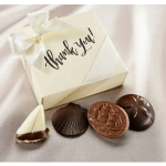 Box of chocolates with a white ribbon and thank-you tag