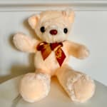 Cream teddy bear with a red ribbon bow