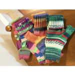 Colorful knitted fingerless gloves stacked on a wooden chair