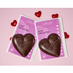 Two heart-shaped dark chocolates in pink wrappers with red heart decorations