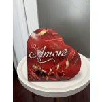 Heart-shaped box of assorted chocolates on a white table