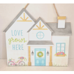 Decorative wooden house sign with the words "love grows here"