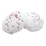 Two white frosted treats with red sprinkles on a white background