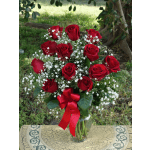 Red roses with baby's breath in a glass vase and red ribbon
