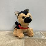 Tan and black plush dog with a red collar sitting on a tiled surface.