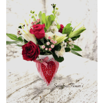 Bouquet of red and white roses in a white vase with a red heart tag
