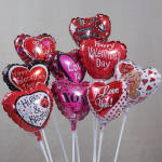 Heart-shaped Valentine balloons with messages on white sticks
