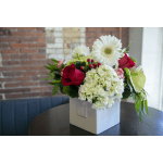Red roses and white daisies in a white square vase