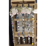 Beaded hanging strands with tags displayed on a wooden rack