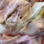 Pile of pastel silk fabric strips in pink, cream, and lavender