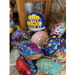 Cluster of colorful birthday balloons with one reading Happy Birthday